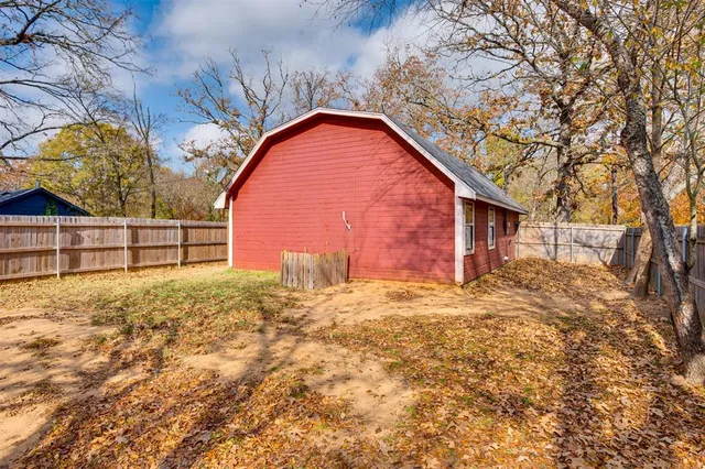 a view of backyard of house with wooden fence