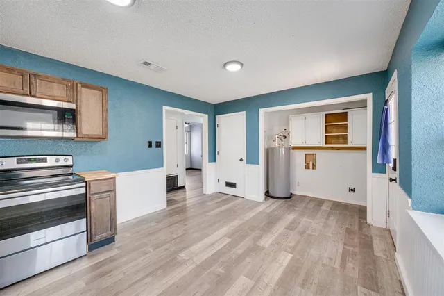 a view of a kitchen with wooden floor and electronic appliances