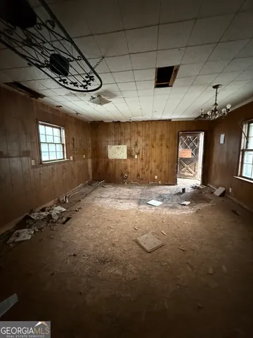 a white house that has a small yard and large parking space