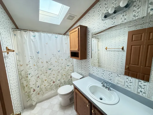 a bathroom with a granite countertop sink toilet and shower