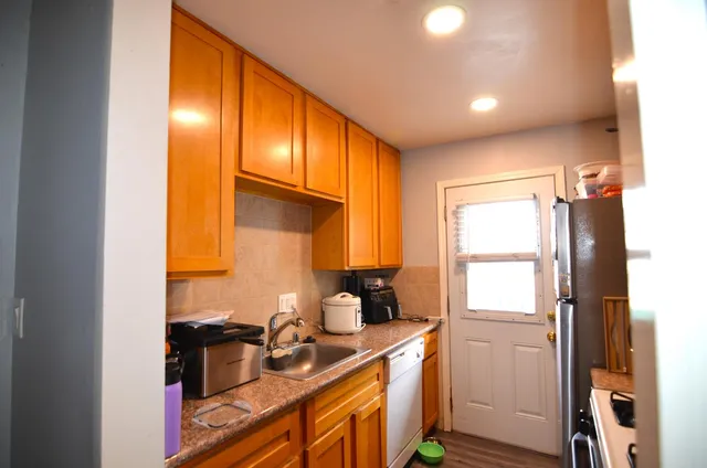 a kitchen with a sink a refrigerator and cabinets