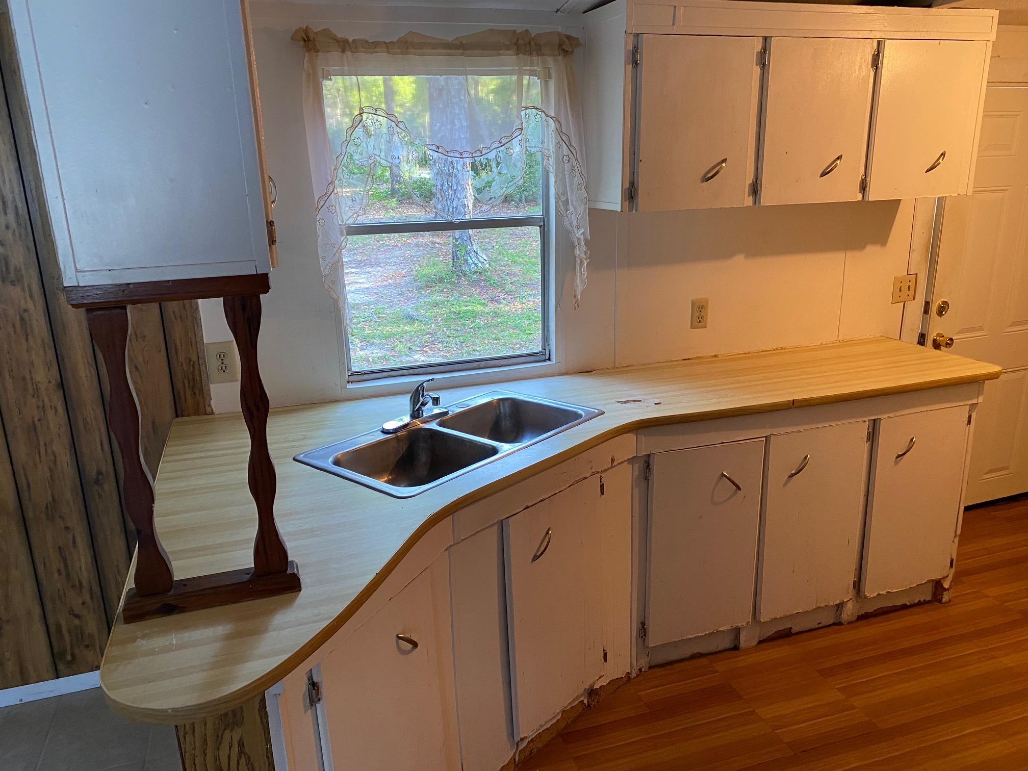 196 Indian Lakes Road Hawthorne, FL 32640 - Photo 25 of 27 a kitchen with stainless steel appliances granite countertop a sink stove and cabinets