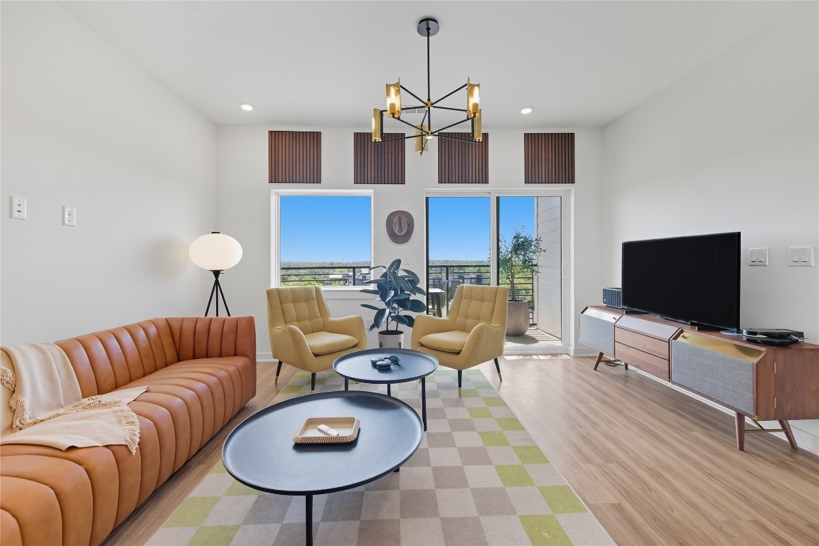 Living room with wood finished floors, a chandelier, and recessed lighting