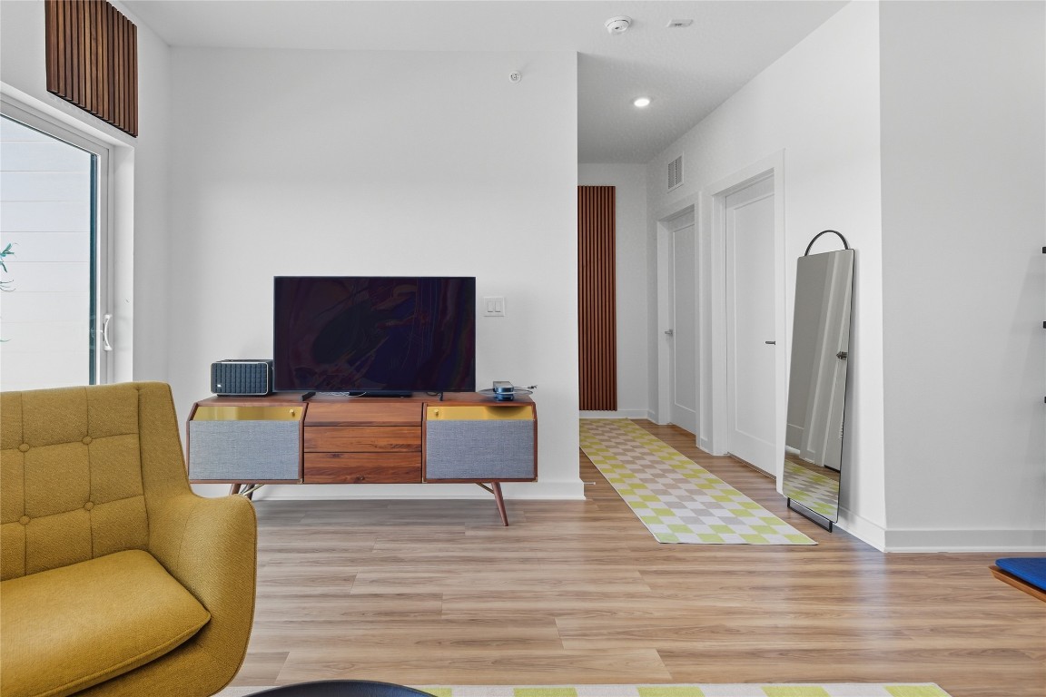 4802 South Congress Avenue, Unit 507 Austin, TX 78745 - Photo 11 of 30 Living room featuring light wood-style floors and baseboards