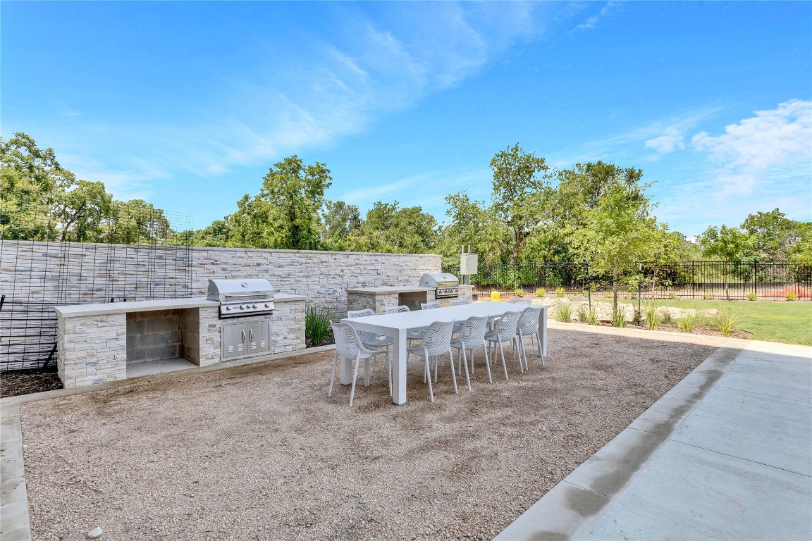 4802 South Congress Avenue, Unit 507 Austin, TX 78745 - Photo 27 of 30 Fenced backyard with an outdoor kitchen, a patio, and outdoor dining area