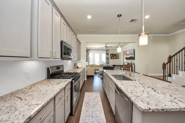 a view of kitchen island a sink and a refrigerator