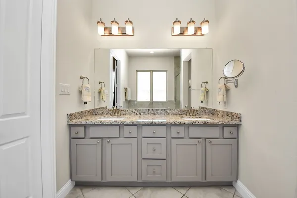 a bathroom with a granite countertop sink a mirror and a vanity
