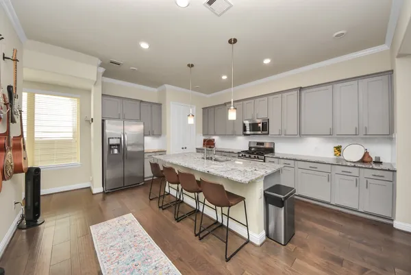 a kitchen with granite countertop a table chairs stove and kitchen island