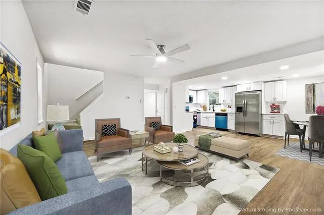 a living room with furniture kitchen view and a chandelier