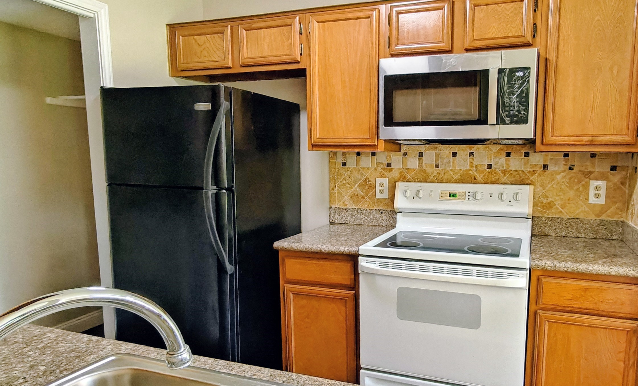 8413 Sands Point Drive Houston, TX 77036 - Photo 9 of 23 a kitchen with a stove microwave and refrigerator