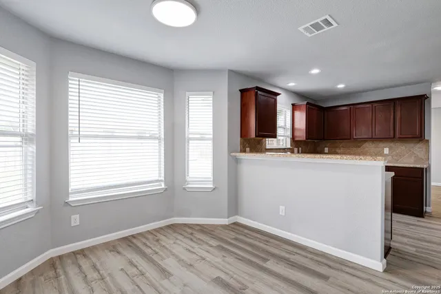 a view of kitchen cabinets and wooden floor