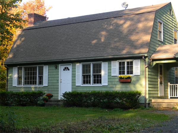 103 Hartland Road Tolland, MA 01034 - Photo 1 of 12 a front view of a house with a yard and plants