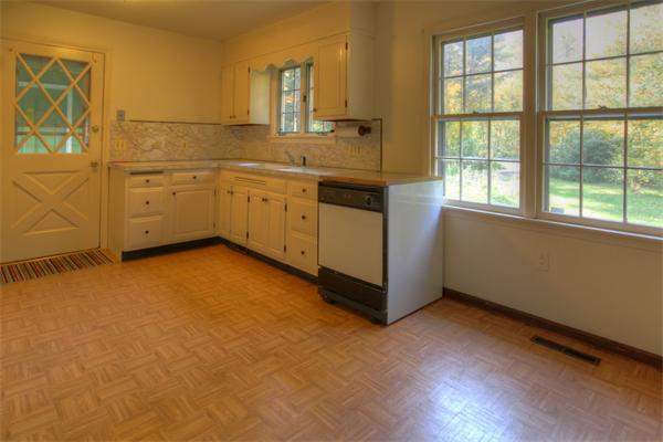 103 Hartland Road Tolland, MA 01034 - Photo 5 of 12 a view of a kitchen with a sink dishwasher and wooden floor