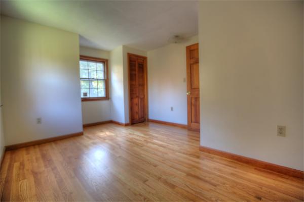 103 Hartland Road Tolland, MA 01034 - Photo 10 of 12 an empty room with wooden floor and windows