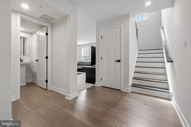 a view of a hallway with wooden floor and staircase