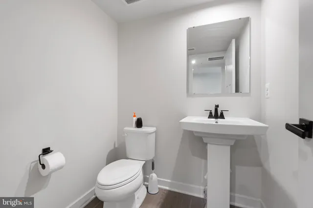 a bathroom with a toilet sink and mirror