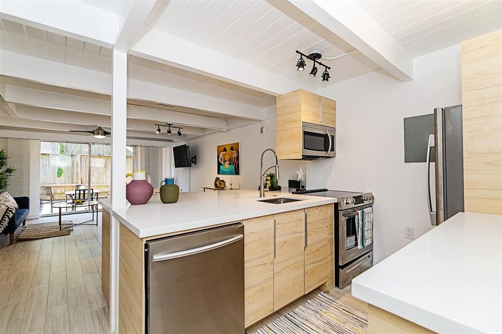 a kitchen with a sink appliances and wooden floor