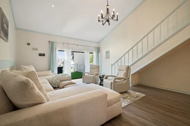a living room with furniture chandelier and a dining table