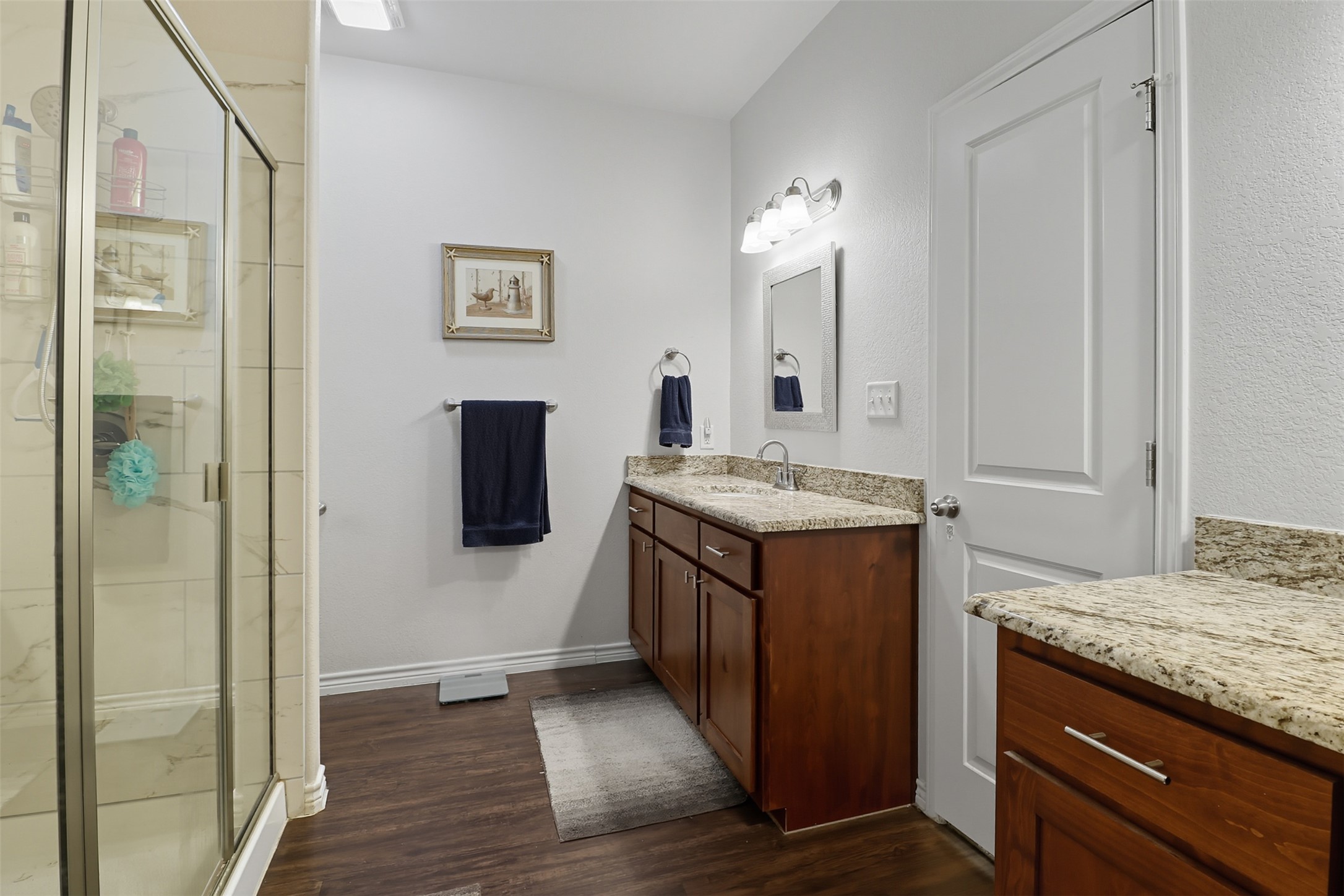 113 Rio Vista Road Burnet, TX 78611 - Photo 12 of 28 Bathroom with a shower stall, vanity, and dark wood-type flooring