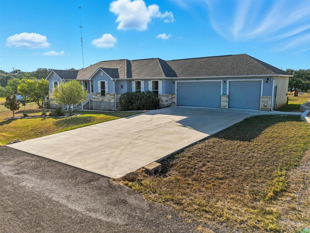 113 Rio Vista Road Burnet, TX 78611 - Photo 3 of 28 Ranch-style house featuring a front lawn, concrete driveway, stone siding, and a garage