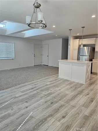 a view of a kitchen with furniture and wooden floor