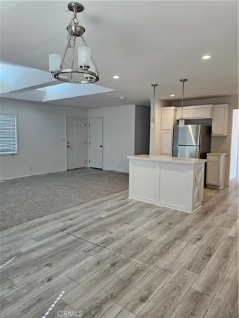 a view of a hallway with wooden floor and chandelier