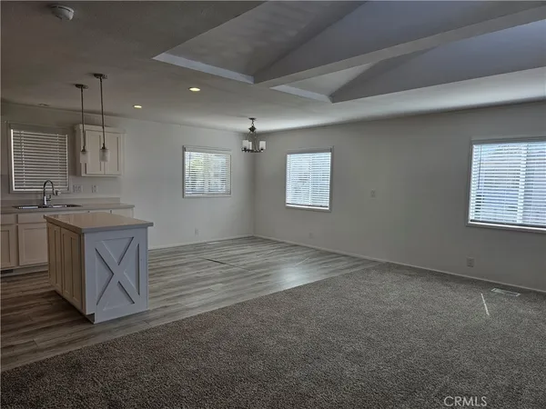 a view of an empty room with a kitchen