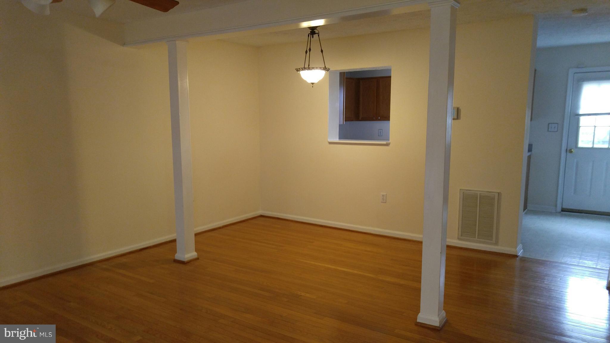 102 Chatham Square Winchester, VA 22601 - Photo 4 of 29 a view of an empty room with wooden floor and a window