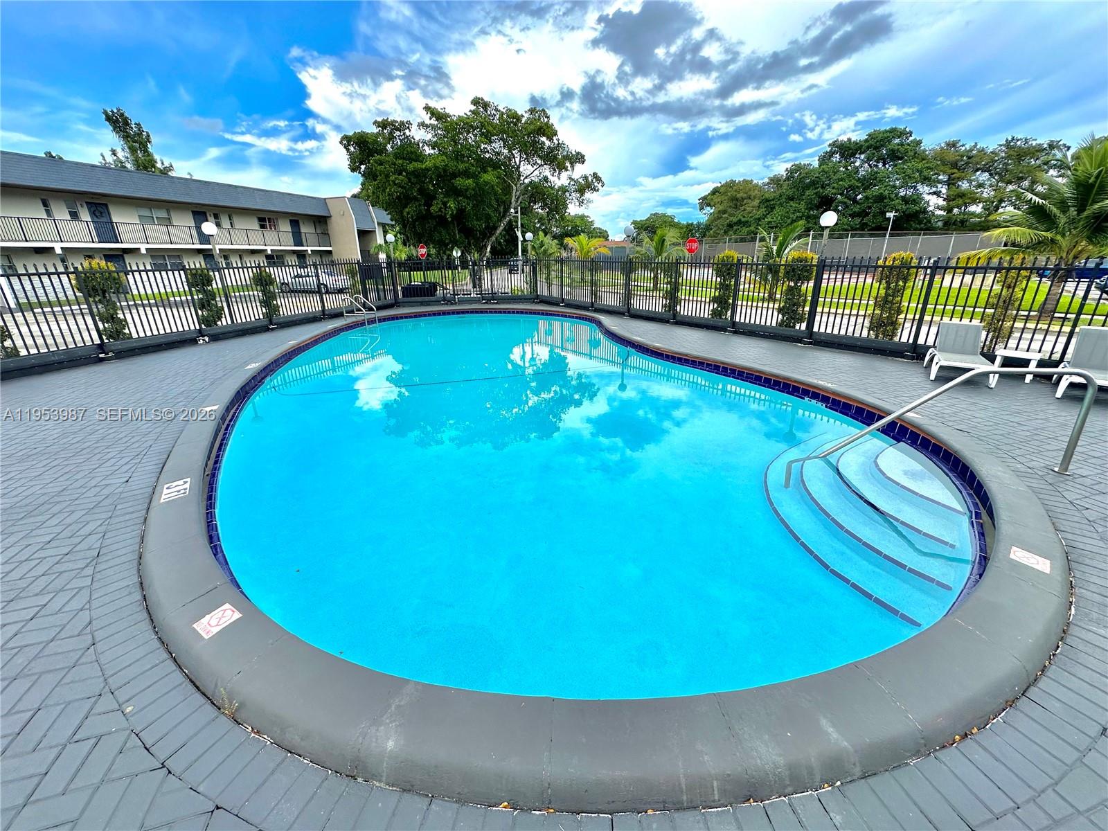 8000 Fairview Drive, Unit 203 Tamarac, FL 33321 - Photo 19 of 29 a view of a swimming pool with a patio and a yard