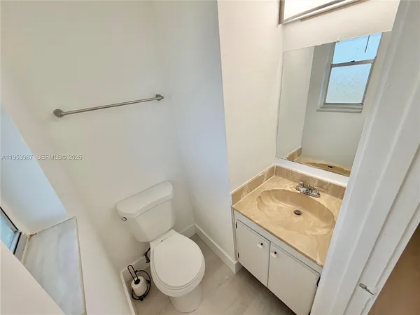 a bathroom with a granite countertop toilet sink and mirror