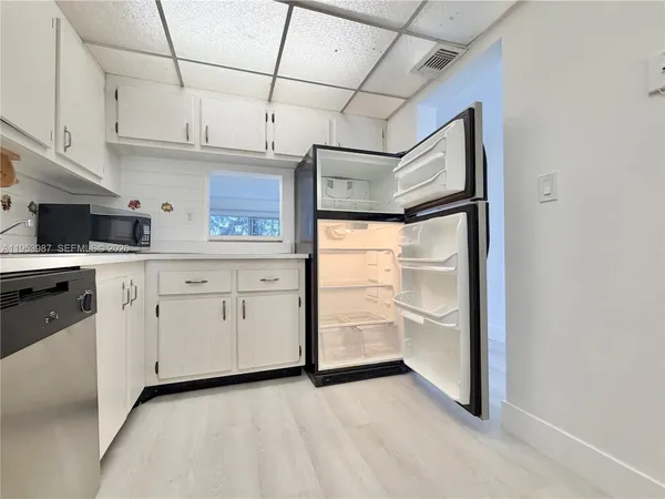 a kitchen with white cabinets and white appliances