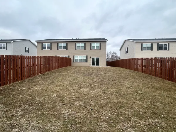 a view of house with yard and sitting area