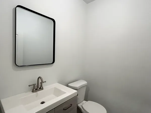 a bathroom with a toilet sink and mirror