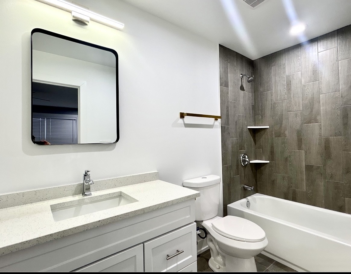 1400 8th Street Harvard, IL 60033 - Photo 8 of 11 a bathroom with a sink toilet a mirror and vanity