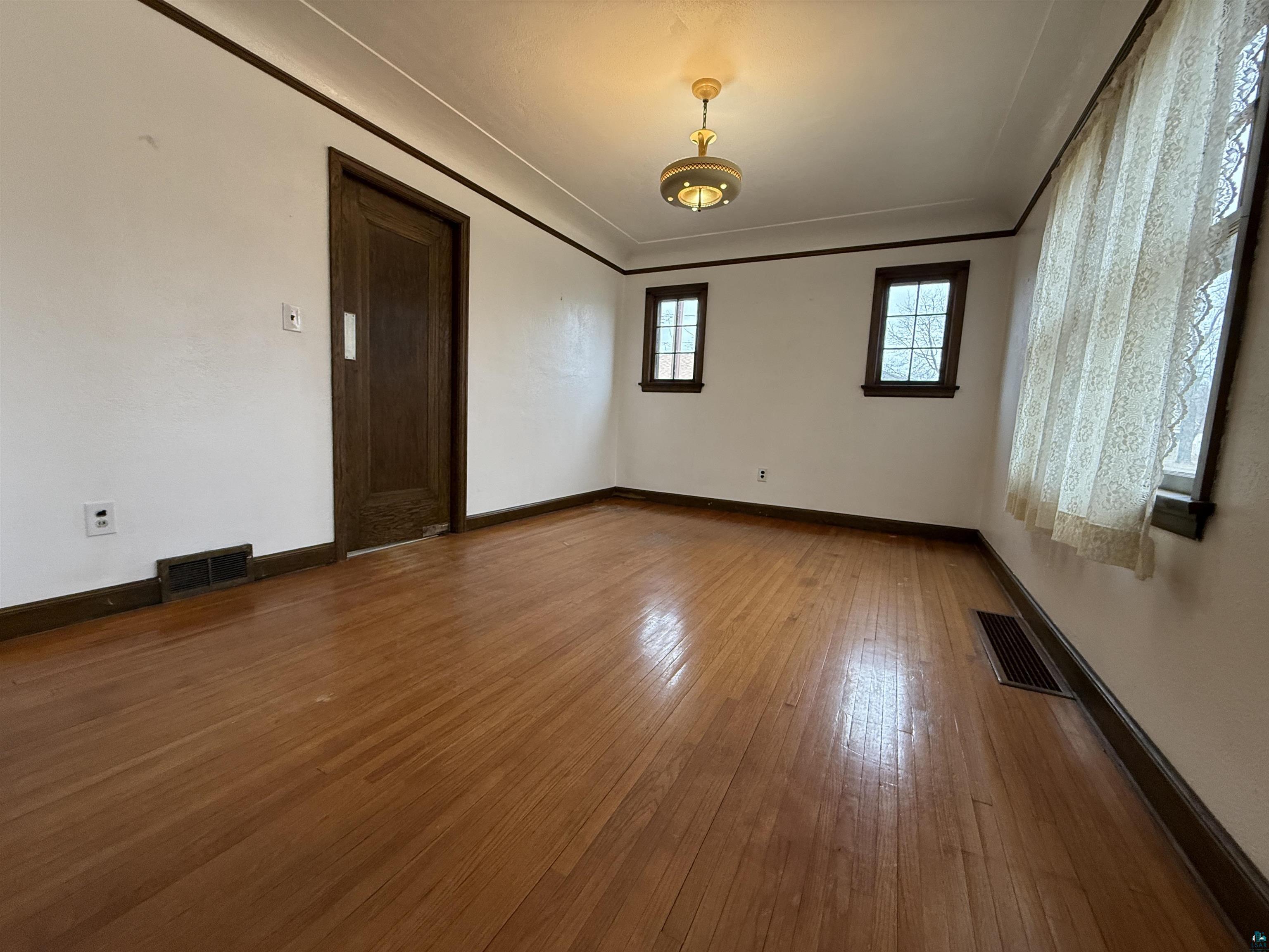 3001 3rd Avenue West Hibbing, MN 55746 - Photo 12 of 38 Unfurnished room with ornamental molding and dark wood-style floors