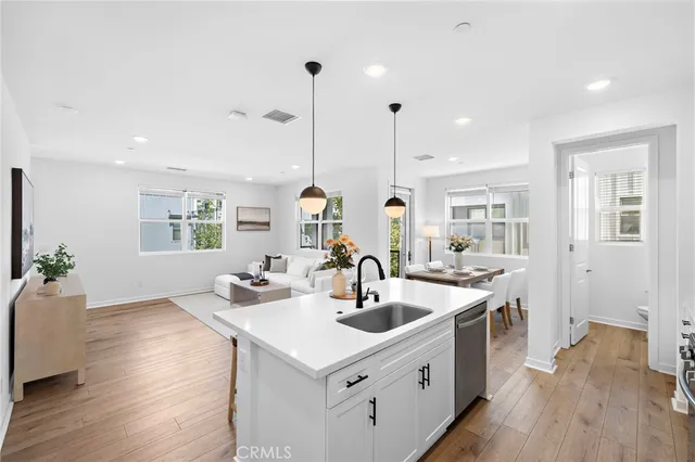 a kitchen with stainless steel appliances kitchen island a sink stove and wooden floor