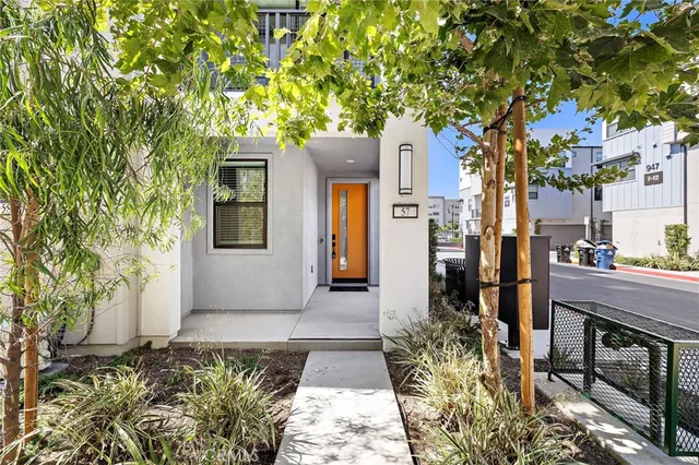 a front view of a house with a tree