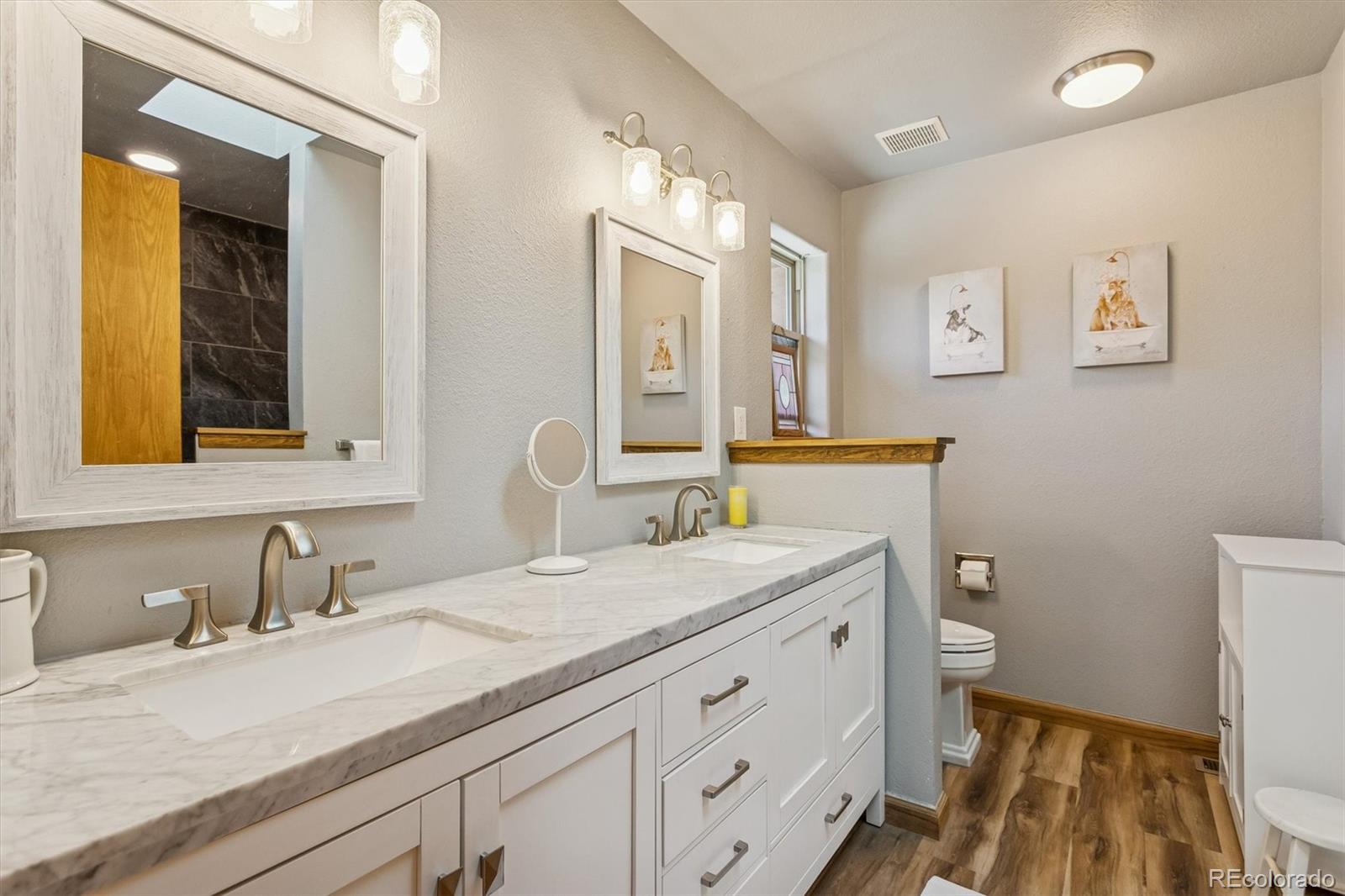2230 County Road 72 Bailey, CO 80421 - Photo 20 of 50 a bathroom with a granite countertop sink mirror vanity and a toilet