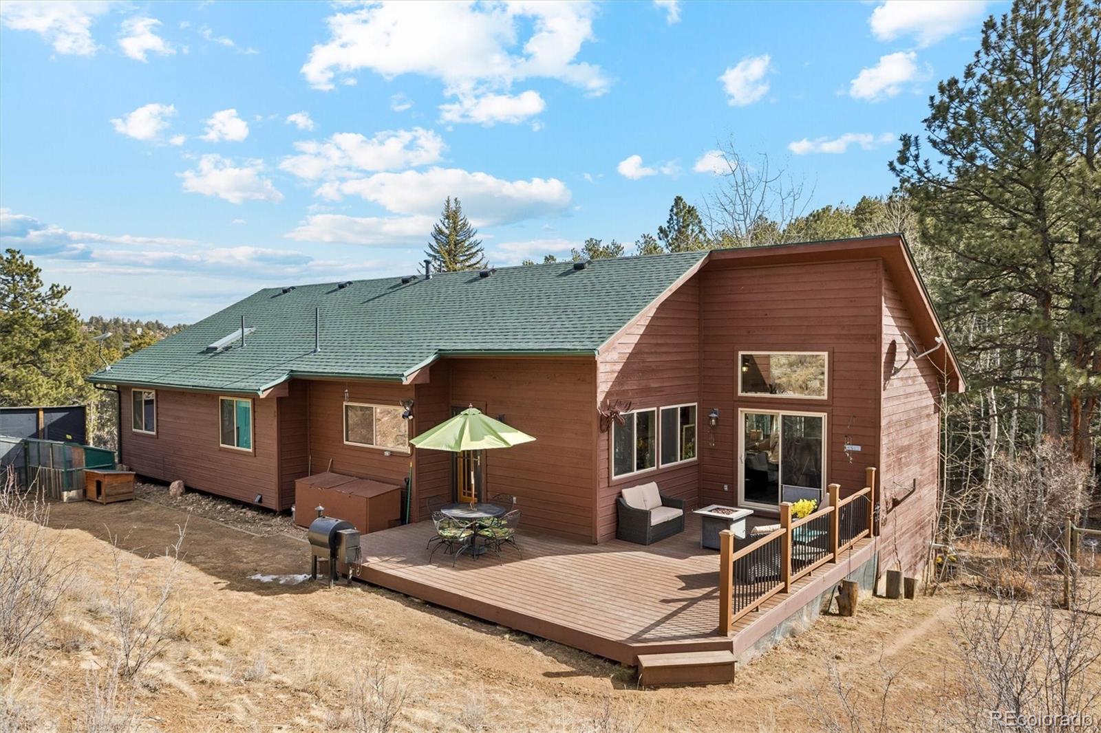 2230 County Road 72 Bailey, CO 80421 - Photo 31 of 50 a front view of house with yard outdoor seating and barbeque oven