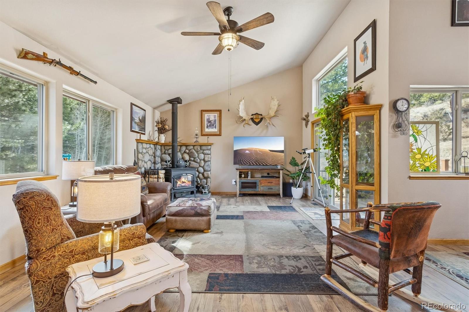 2230 County Road 72 Bailey, CO 80421 - Photo 4 of 50 a living room with furniture a fireplace and a large window