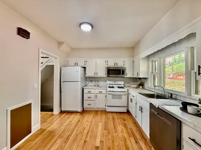 a kitchen with stainless steel appliances a stove refrigerator sink and microwave