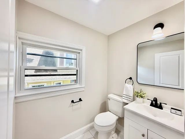 a bathroom with a toilet a sink a vanity and mirror
