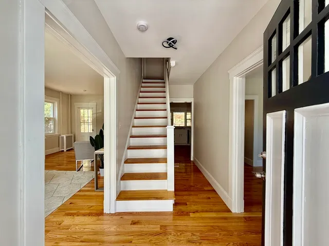 a view of entryway and hall with wooden floor