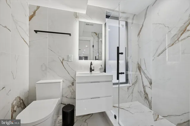 a white toilet sitting next to a bathroom sink