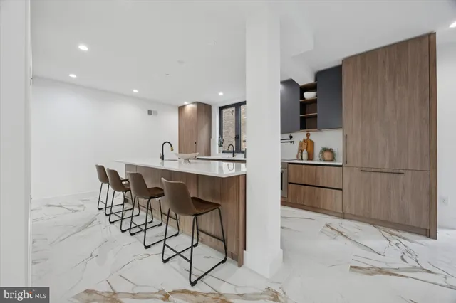 a large kitchen with stainless steel appliances a sink and cabinets