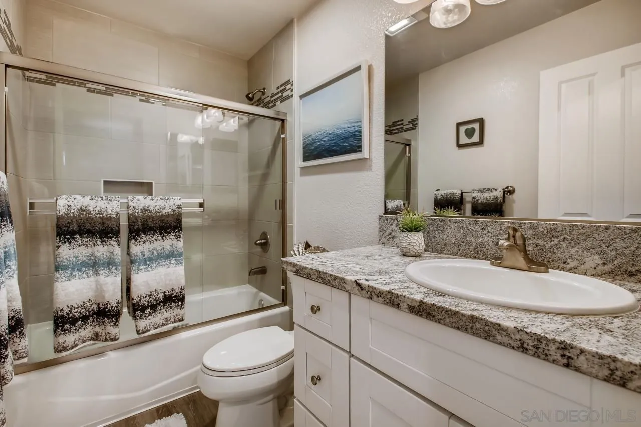 8524 Via Mallorca, Unit E La Jolla, CA 92037 - Photo 11 of 14 a bathroom with a granite countertop sink toilet and shower