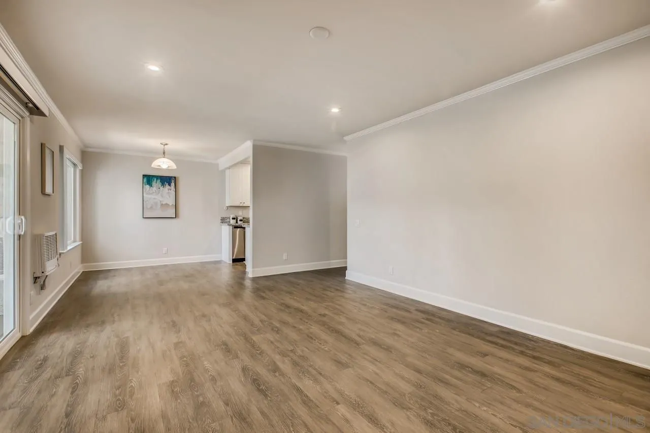 8524 Via Mallorca, Unit E La Jolla, CA 92037 - Photo 3 of 14 an empty room with wooden floor and windows