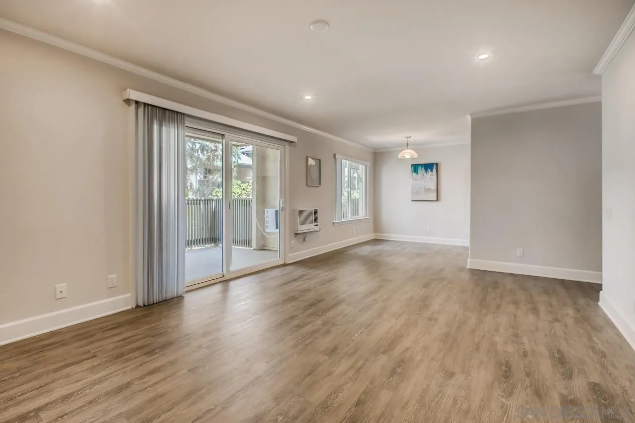 8524 Via Mallorca, Unit E La Jolla, CA 92037 - Photo 4 of 14 a view of an empty room with wooden floor and a window
