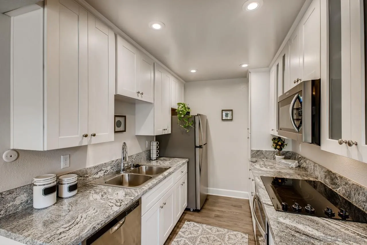 8524 Via Mallorca, Unit E La Jolla, CA 92037 - Photo 6 of 14 a kitchen with stainless steel appliances granite countertop a sink stove and refrigerator