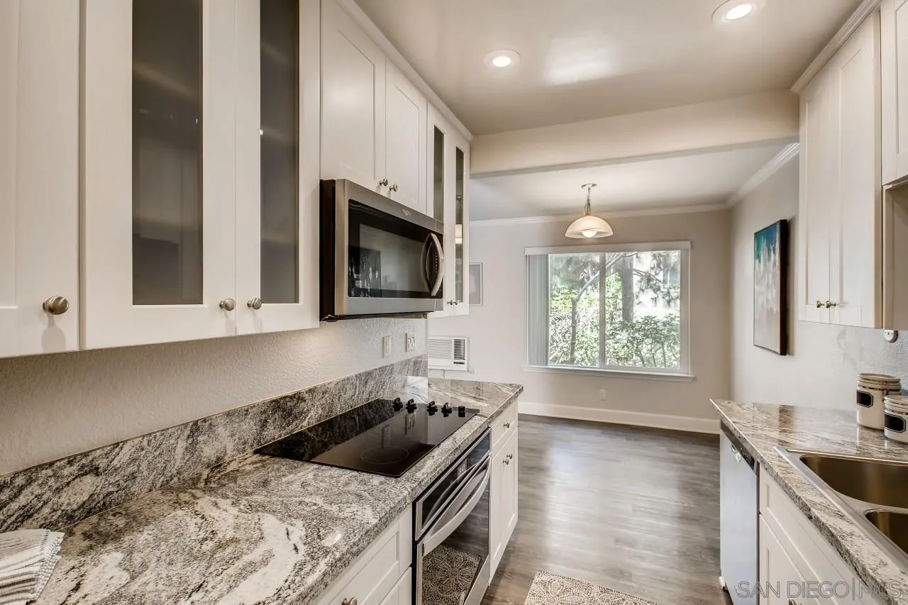 8524 Via Mallorca, Unit E La Jolla, CA 92037 - Photo 7 of 14 a kitchen with stainless steel appliances granite countertop a sink a stove a microwave a counter space and cabinets